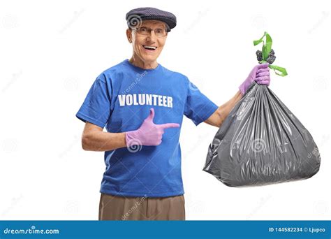 Elderly Male Volunteer Holding A Waste Bag And Pointing Stock Photo
