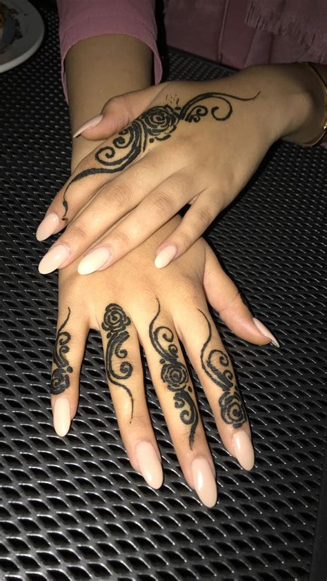 Two Hands With Henna Tattoos On Them