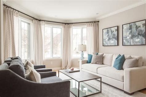 Welcoming Living Room Features Bay Windows Dressed In Cream Curtains