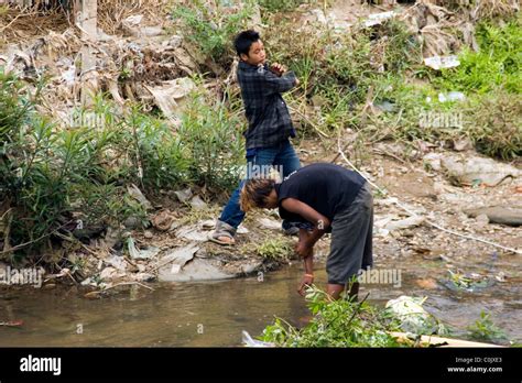 Two Burmese Teenage Boys Are Bathing In A Dirty And Polluted River In