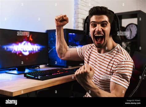 Portrait Of Caucasian Gamer Guy Screaming And Rejoicing While Playing Video Games On Computer