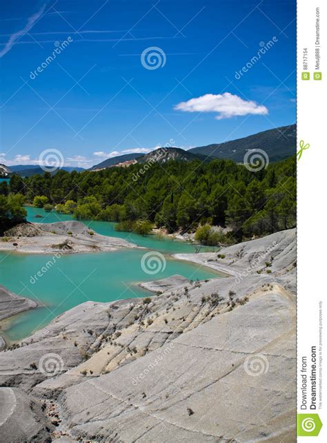 Yellow Trees In Turquoise Artificial Lake In Blue Sky In Summertime