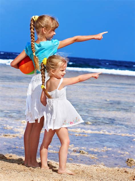 Zwei Kleine Mädchen Mit Den Ballonen Die Auf Dem Strand Am Tag Stehen Stockbild Bild Von