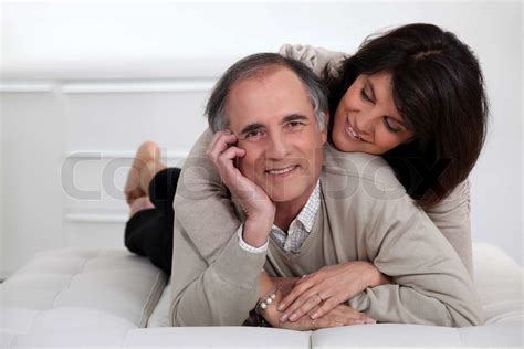 Mature Couple Lying In Bed Showing Their Affection Stock Image