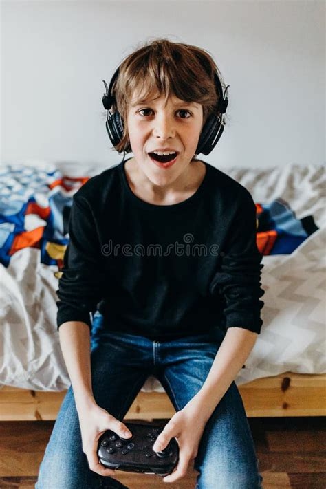 White Young Boy Playing Video Games In The Bedroom The Concept Of