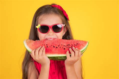 Cute Little Girl Holding Eating Juicy Slice Of Watermelon Over Yellow