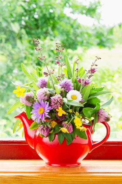 Premium Photo Red Teapot With Bouquet Of Healing Herbs And Flowers On