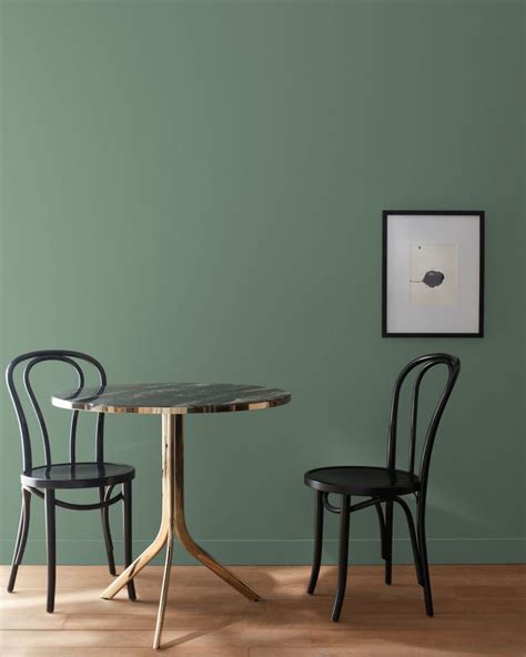 Two Chairs Sitting At A Table In Front Of A Wall With Green Paint On It