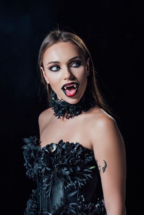 A Woman In Black Dress With Her Mouth Open And Makeup Painted To Look Like Vampire