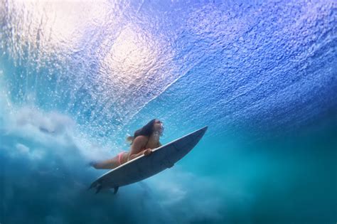 Beautiful Surfer Girl Diving Under Water With Surf Board Stock Photo