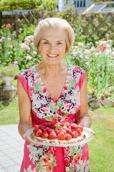 Mature Woman Holding Strawberry Tart Stock Photo Dissolve
