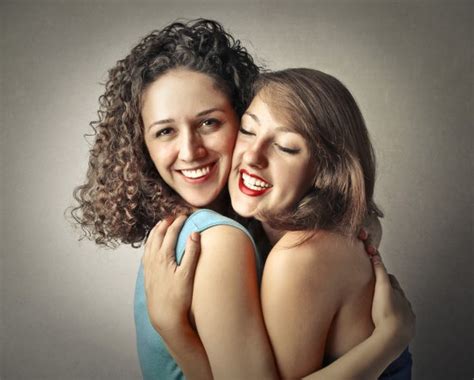 Two Young Female Friends Hugging Each Other Smiling Stock Photo By
