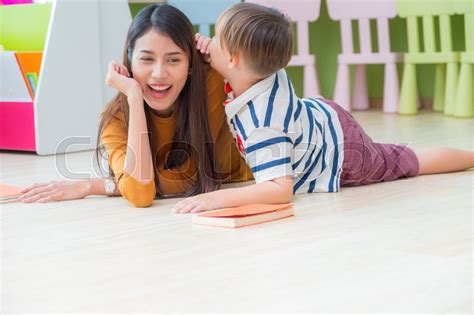 Kid Boy Whisper Teacher While Lay Down Stock Photo