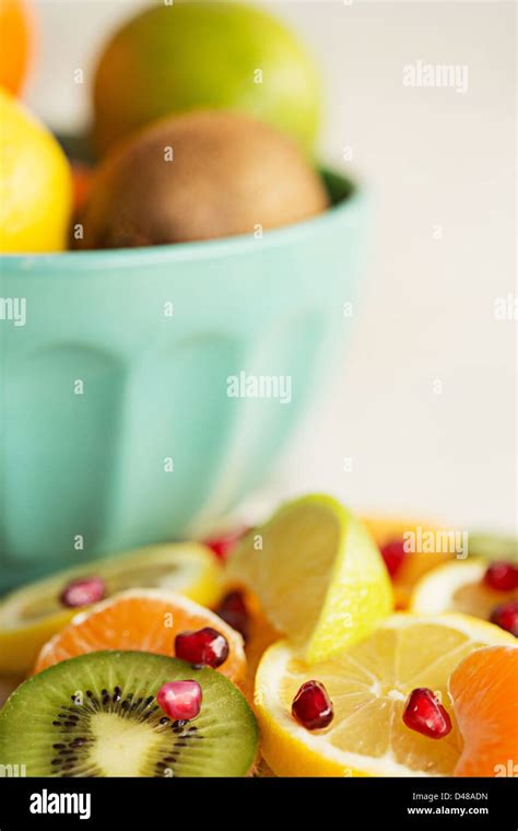 A Bowl Of Citrus Fruits Surrounded By Fruit Segments And Slices On A