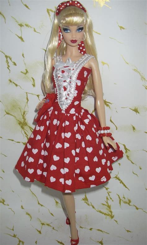 A Barbie Doll Wearing A Red And White Dress With Hearts On Its Chest