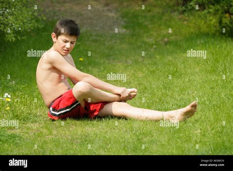 Portrait d un jeune garçon qui a blessé son pied marche pieds nus Photo