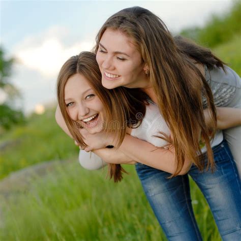 Dos Amigas Adolescentes Que Ríen Divirtiéndose En Primavera O Verano Al Aire Libre Imagen de