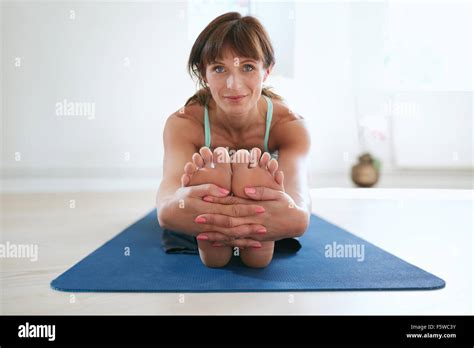 Woman In Seated Forward Bend Yoga Pose Holding Feet Fitness Trainer Practicing
