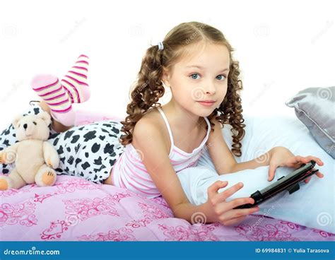 Glückliches Kleines Mädchen Das Auf Bett Mit Tablet Computer Liegt
