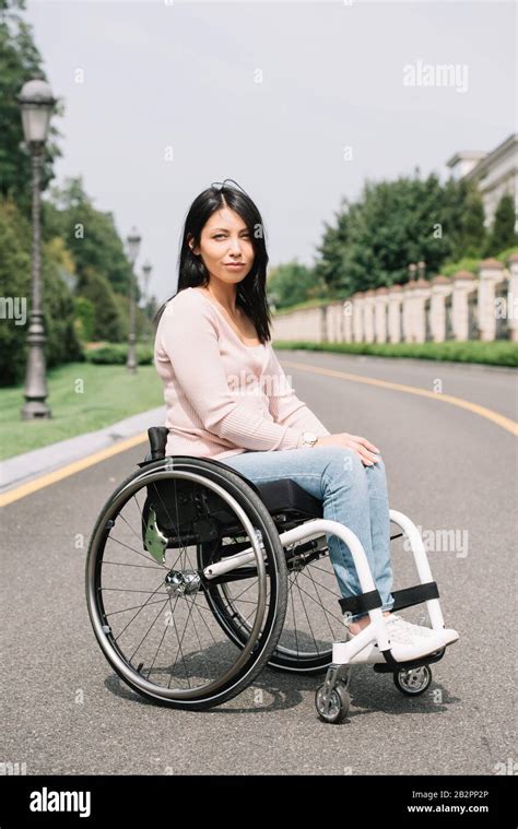 Attractive Disabled Woman In Wheelchair Looking At Camera Stock Photo