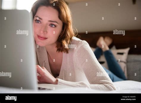 Caucasian Woman Laying On Bed Using A Laptop Stock Photo Alamy
