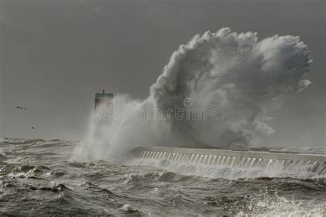 Breathtaking View Of Big Stormy Waves Crashing Against The Lighthouse