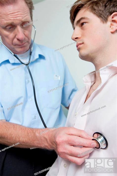 Doctor Using Stethoscope On Patient During Medical Examination Stock