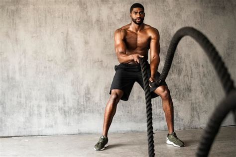 Premium Photo Muscular Man Working Out On The Battle Ropes In A Gym