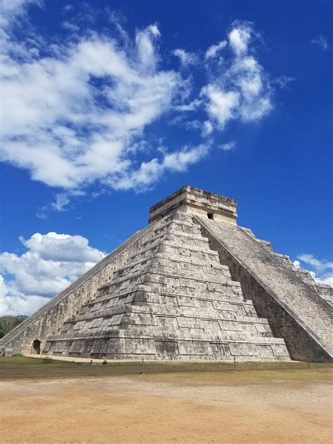 An Image Of A Pyramid In The Middle Of The Day With Clouds Above It And