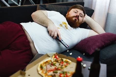 Free Photo Sad Fat Man Lies On The Sofa And Watches Tv