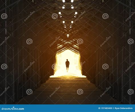 Silhouette Of A Man Walking Into Light At The End Of A Tunnel Stock