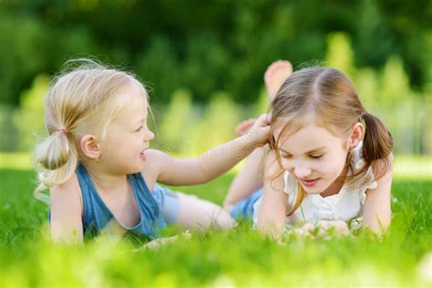 Two Cute Little Sisters Having Fun Together On The Grass On Summer Day Stock Image Image Of