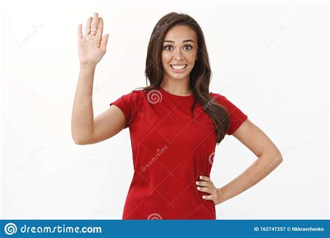 Friendly Cute Brunette Girl In Red T Shirt Raising Hand Up Waving Palm