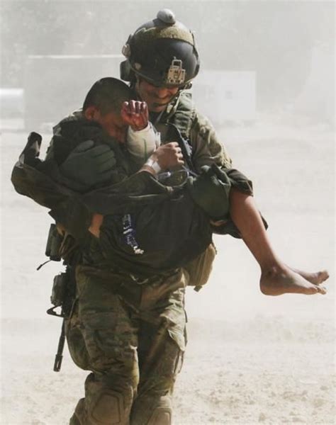 Carrying A Wounded Afghan Child To The Pave Hawk Helicopter In Helmand