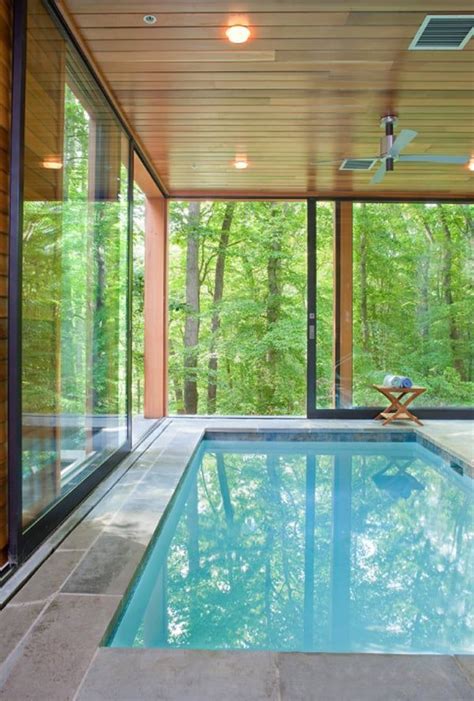 An Indoor Swimming Pool In The Middle Of A House With Glass Walls And