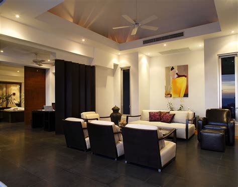 A bright and modern open concept living room with black tile floor and high ceilings ...