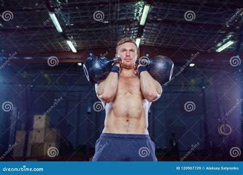 cross training fit fitness man doing a weight training by lifting kettlebell stock image