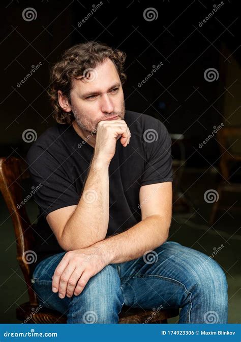 Portrait Of Brooding Man Sitting On Chair Stock Photo Image Of