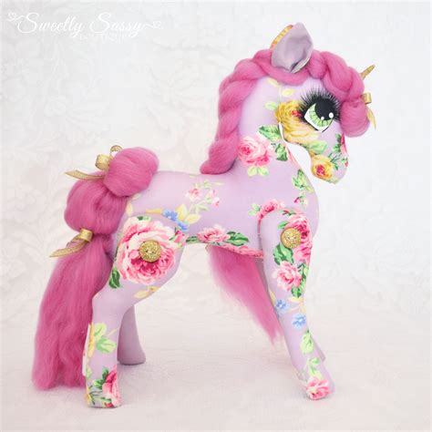 A Toy Horse With Pink Hair And Flowers On Its Body Standing In Front