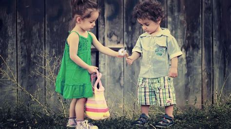 Cute Little Girl Is Giving Flower To The Boy Wearing Green