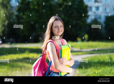 Girl Schoolgirl In Summer After School In The Hands Holds A Notebook Backpack The Concept Of