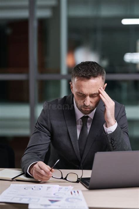 Overworked Businessman In Formalwear Bending Over Laptop In Office