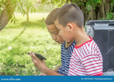 Happy Cute Asian Boys Play Game With Smartphone Sit On Car Stock Photo