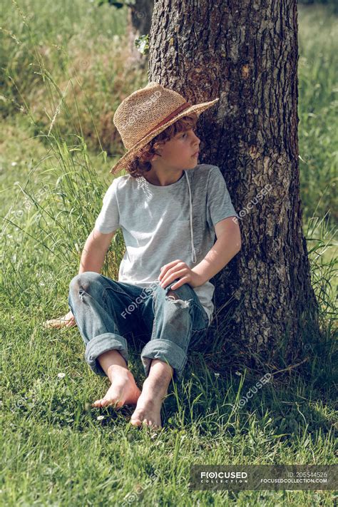 Barefoot Boy Sitting Under Tree — Enjoyment Vertical Stock Photo
