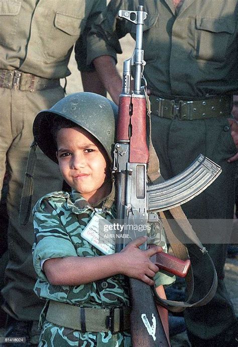 An Iraqi Boy Poses With An Ak47 Assault Rifle At A Ceremony For News
