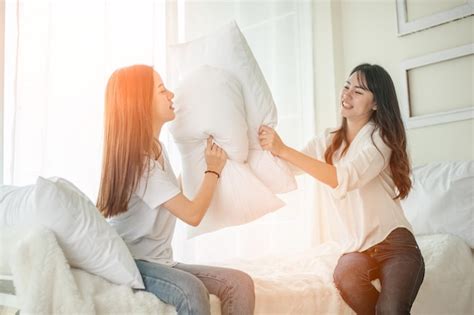 mujeres lesbianas en peleas de almohadas en el dormitorio foto premium