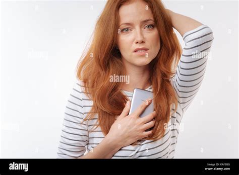Upset Ginger Haired Woman Pressing Phone To Her Chest Stock Photo Alamy