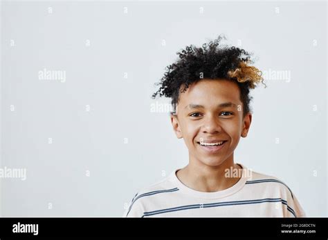 Minimal Portrait Of Mixed Race Teenage Boy Smiling At Camera Against