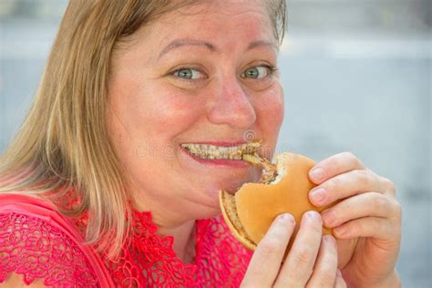 Thick Woman Eating Fast Food Hamburger And French Fries In A Cafe At A