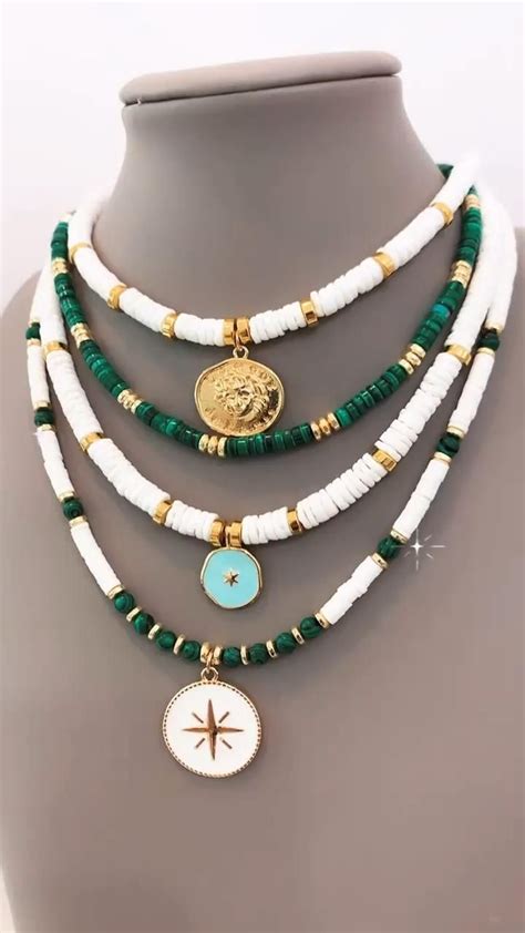 A White And Green Beaded Necklace On A Mannequin With A Gold Medallion